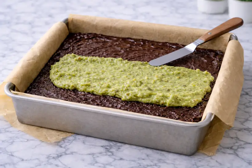 Creating the pistachio layer inside a Dubai chocolate brownie before baking