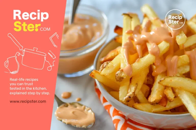 Crispy fries drizzled with creamy orange BBQ mayo sauce, with a glass bowl of the same sauce and a spoon in the background.