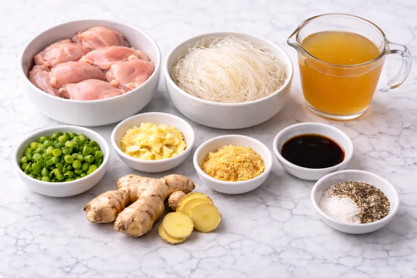 straining chicken broth and separating cooked chicken for chicken long rice recipe