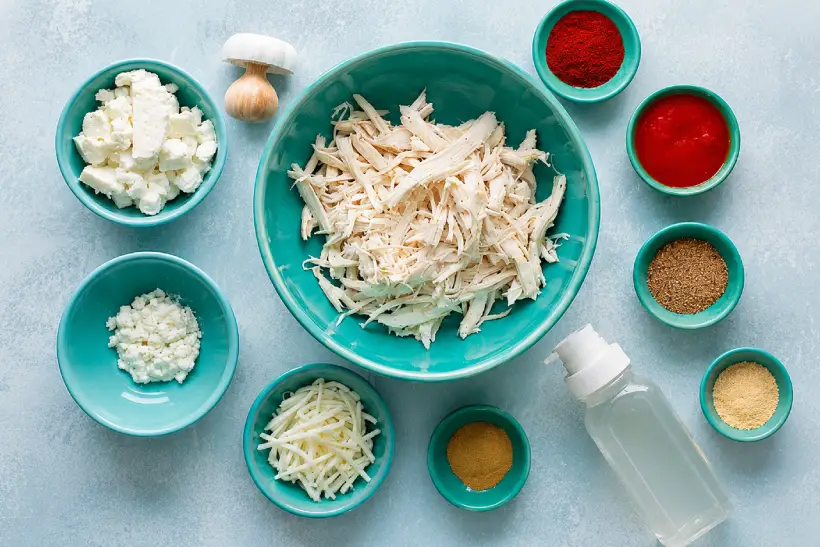 Ingredients for bariatric chicken enchilada bake arranged in turquoise bowls